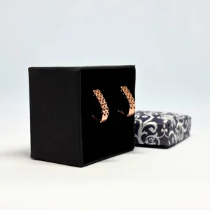 "Elegant rose gold spiral loop earrings displayed in a black velvet box with floral gift packaging"