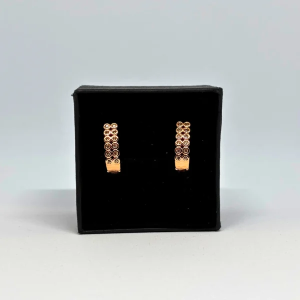 "Elegant rose gold spiral loop earrings displayed in a black velvet box with floral gift packaging"