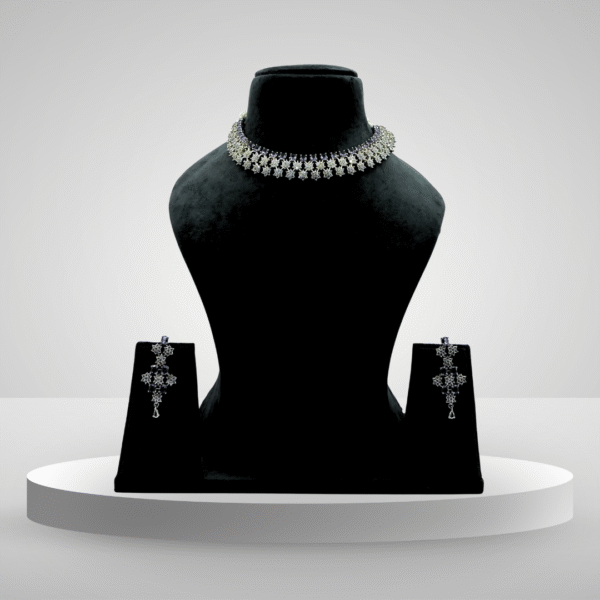 Elegant silver floral choker necklace set with detachable earrings displayed on a black velvet stand against a light grey background