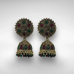 Antique gold jhumka earrings with red and green stones on white background