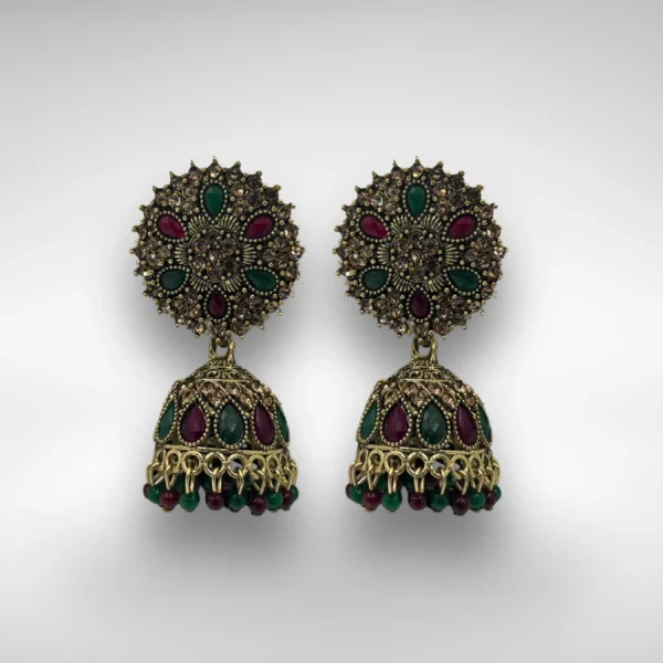 Antique gold jhumka earrings with red and green stones on white background