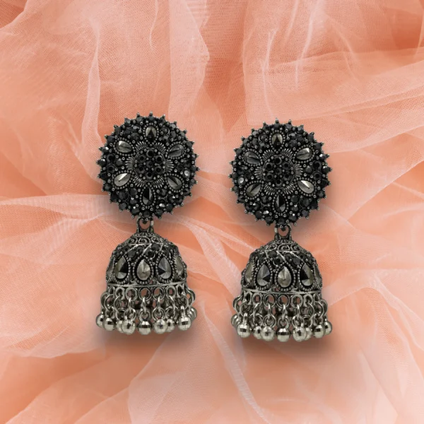Oxidised silver jhumka earrings with floral top and dome base with hanging beads on a white background