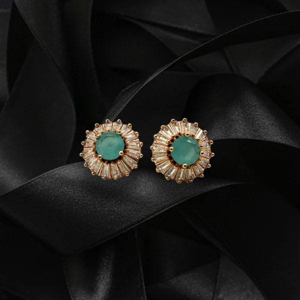 Elegant green stud earrings with baguette-cut crystals on black satin background