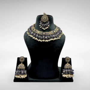 Traditional Indian bridal jewelry set with royal blue Kundan choker necklace, pearl detailing, matching earrings, and maang tikka on a white background