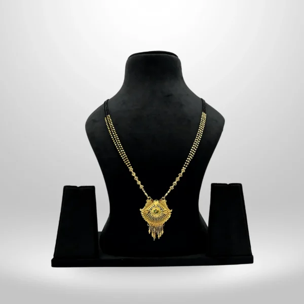 Gold-plated bridal mangalsutra with intricate pendant on black beaded chain displayed on black stand