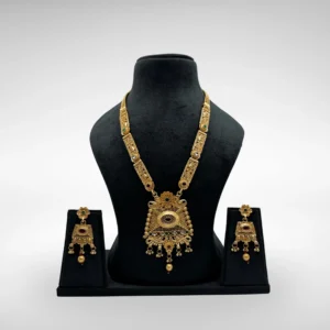 Antique matte gold South Indian temple necklace set with rectangular pendant and earrings on black bust stand against light grey background